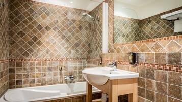 Un baño con bañera, lavamanos y ducha.