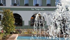 Un edificio con un letrero que dice "Aux Temps d'Em" y "CAFÉ BRASSERIE".
