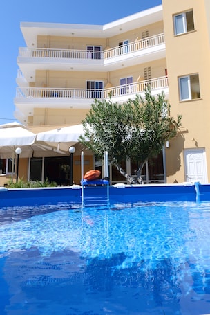 Una piscina al aire libre de temporada, sombrillas