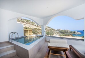A modern infinity pool with a view of the sea, a wooden bench, and a sofa. - Ladiko Suites Faliraki  (Rhodes)