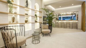 A modern interior with a bar area, seating, and decorative shelves. - Ladiko Suites Faliraki  (Rhodes)