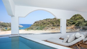 A modern pool area with a view of the beach and hills. - Ladiko Suites Faliraki  (Rhodes)