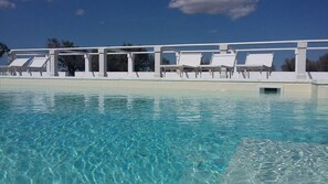 Una piscina al aire libre, tumbonas