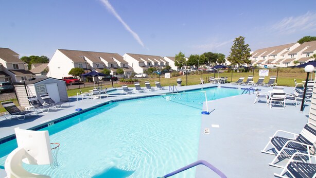 A swimming pool with a 3 FT depth limit, surrounded by lounge chairs and a small shed. - Deercreek Townhomes (Surfside Beach)