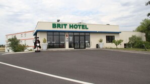 Un hotel Brit con fachada moderna, ventanas amplias y un estacionamiento al frente.