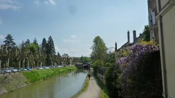 A canal with a pathway alongside, lined with trees and buildings.