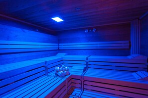 Un sauna avec des bancs en bois et un espace de chauffage central.