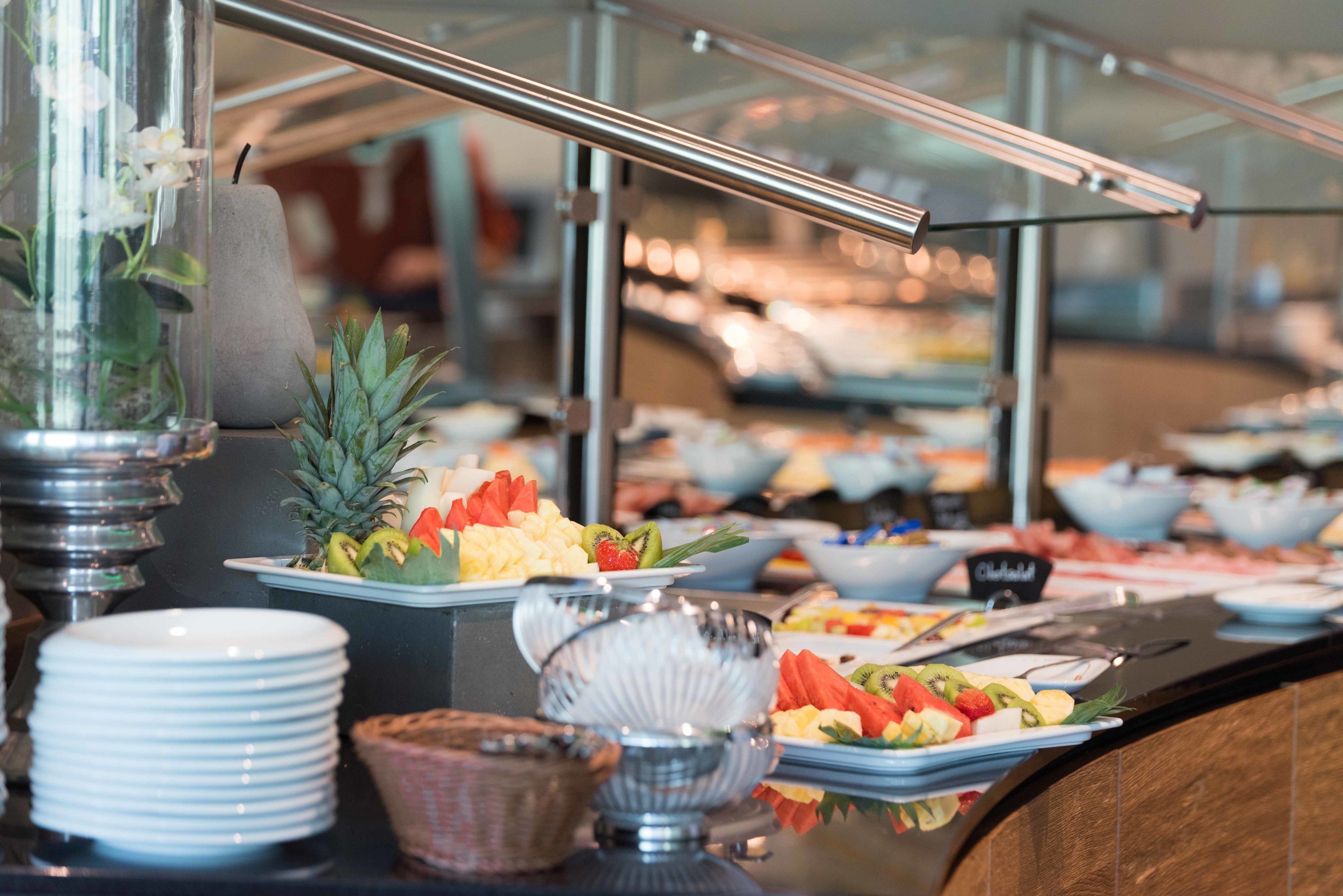 A buffet with various food items and a glass display case.