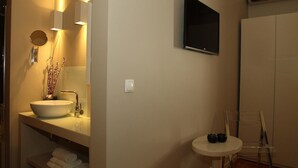 A bathroom with a large sink, mirror, and a small table with two cups. - Castilho House (Lisbon)