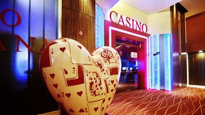 Una gran escultura con forma de corazón y figuras de cartas de juego en el vestíbulo de un hotel.
