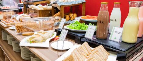A buffet with various food items including sandwiches, salads, and beverages.
