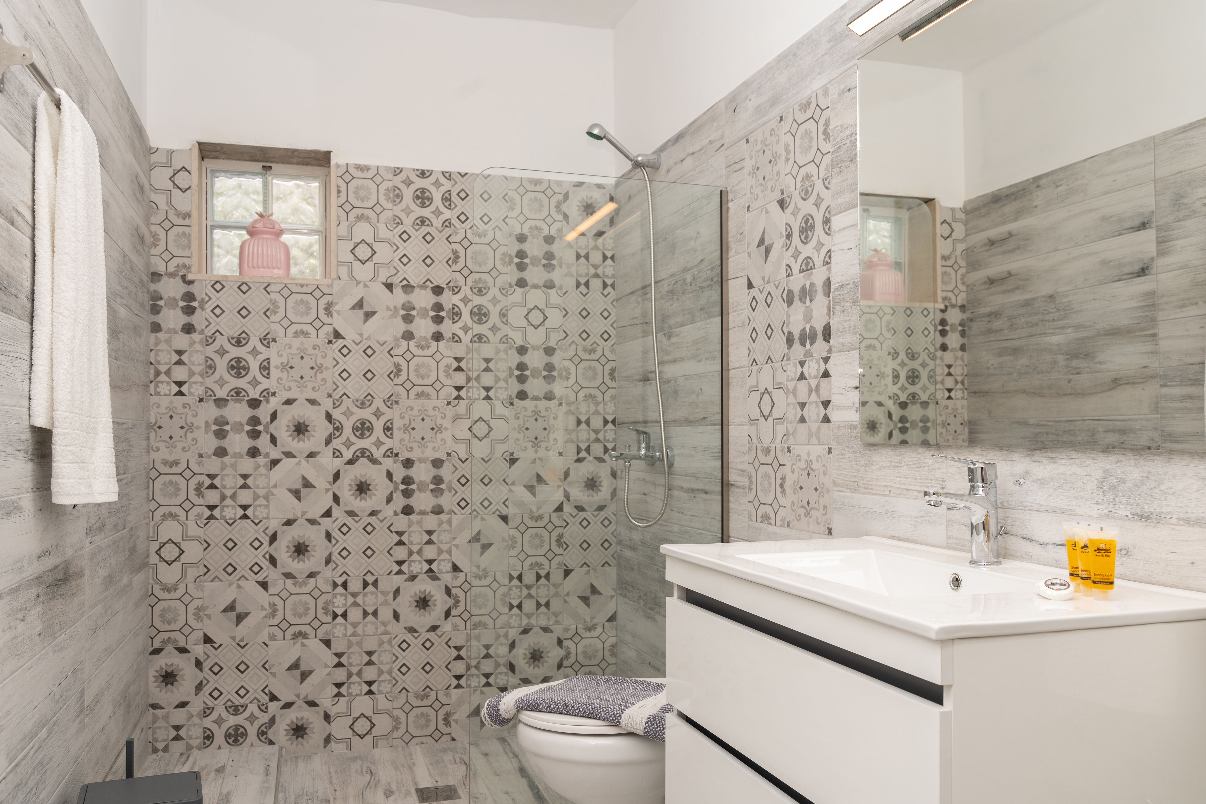 Une salle de bain moderne équipée d’une douche, de toilettes et d’un lavabo.