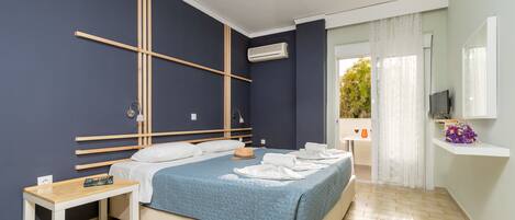 A modern bedroom with a bed, bedside table, and a hanging light fixture.
