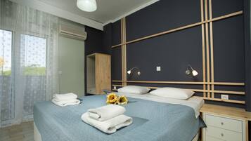 Une chambre à coucher avec un lit, des tables de chevet, une armoire et une fenêtre avec des rideaux.