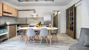 A modern kitchen with a dining table, chairs, and a built-in oven.