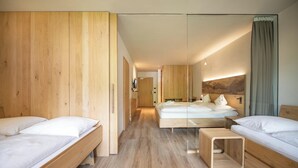 Una habitación de hotel moderna con paredes de madera, una cama grande, una mesita de noche pequeña y un espejo.