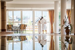 Una piscina techada, sillones reclinables de piscina