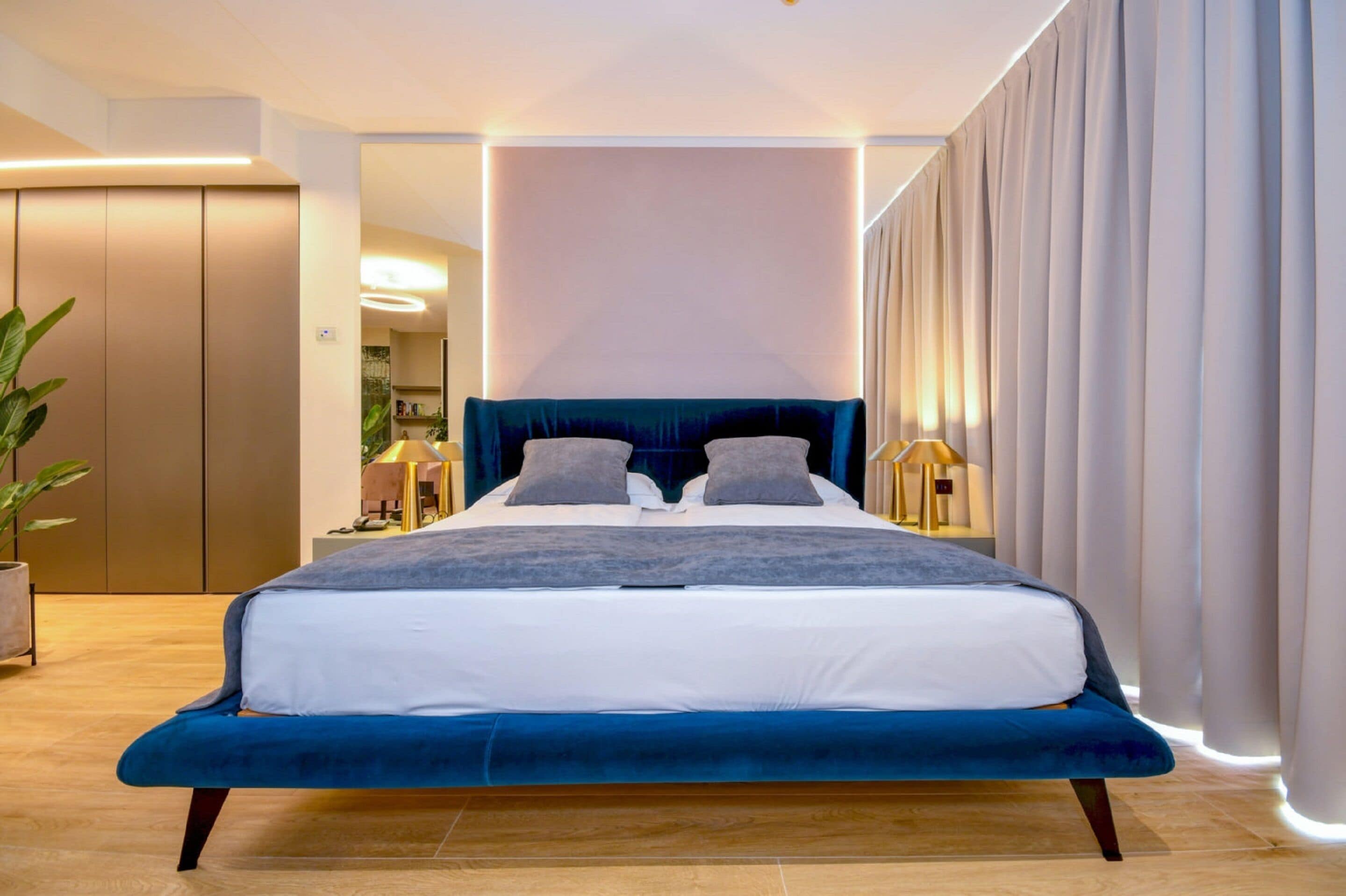 A modern bedroom with a large bed, a bedside table, and a nightstand.