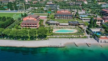 Alberca techada, alberca al aire libre y sombrillas en la alberca