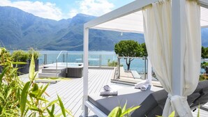 A rooftop terrace with a hot tub, seating area, and a view of mountains and a lake. - Hotel Du Lac (Limone sul Garda)