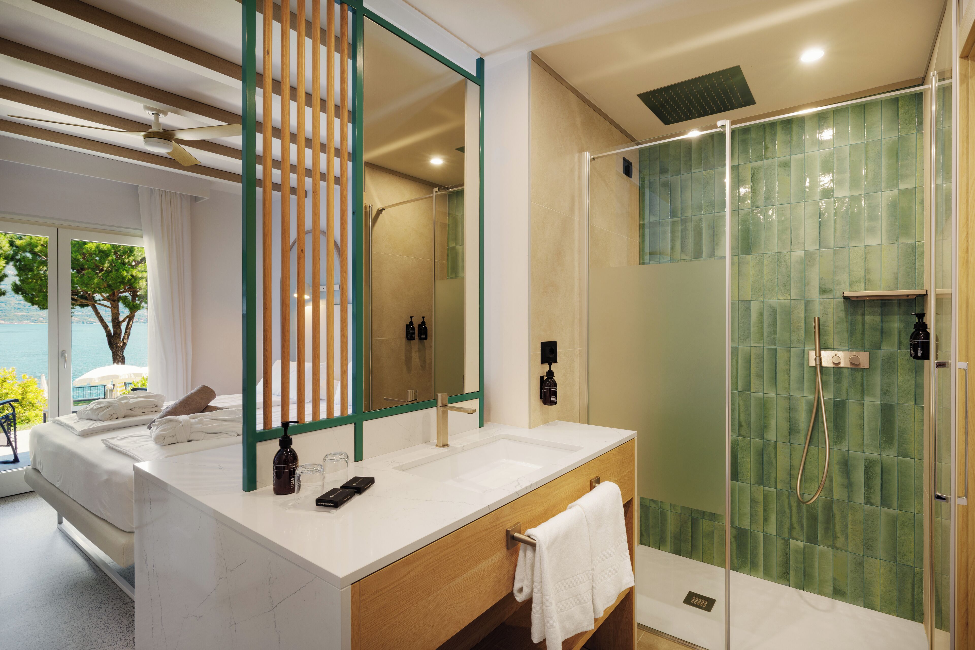A modern bathroom with a large mirror, a shower enclosure, and a view of the sea.