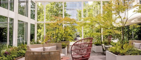 A modern outdoor seating area with wicker furniture and planters.