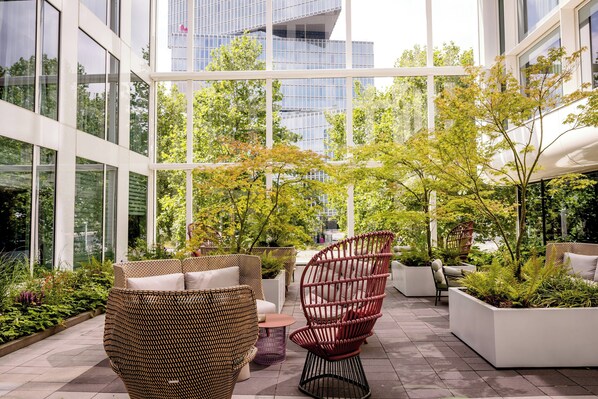 A modern outdoor seating area with wicker furniture and planters.