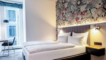 Una habitación de hotel moderna con una cama grande, un escritorio y una silla.