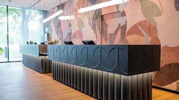 A reception desk with a modern design, a patterned wall, and a wooden floor.