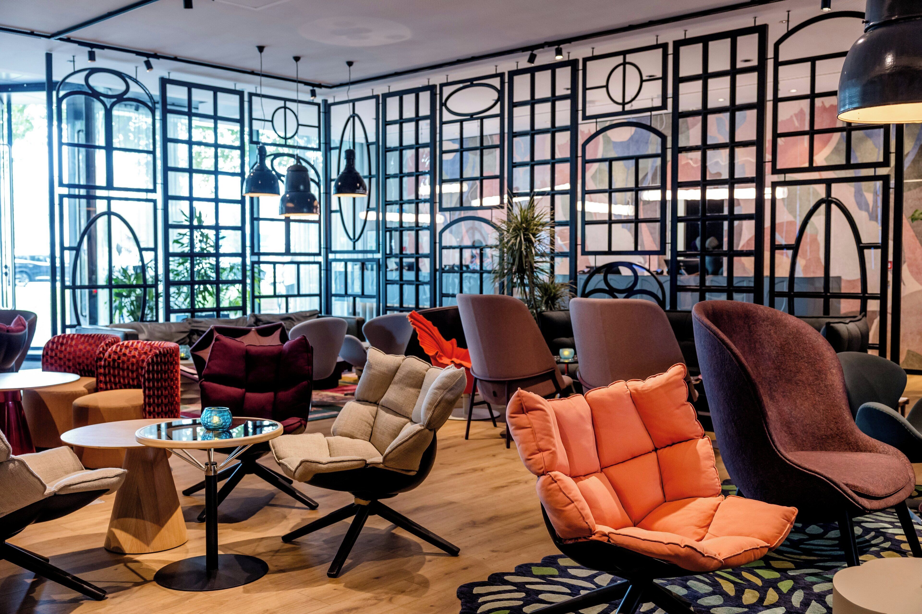 A modern interior with a mix of seating options, including armchairs and sofas, arranged around a central coffee table.