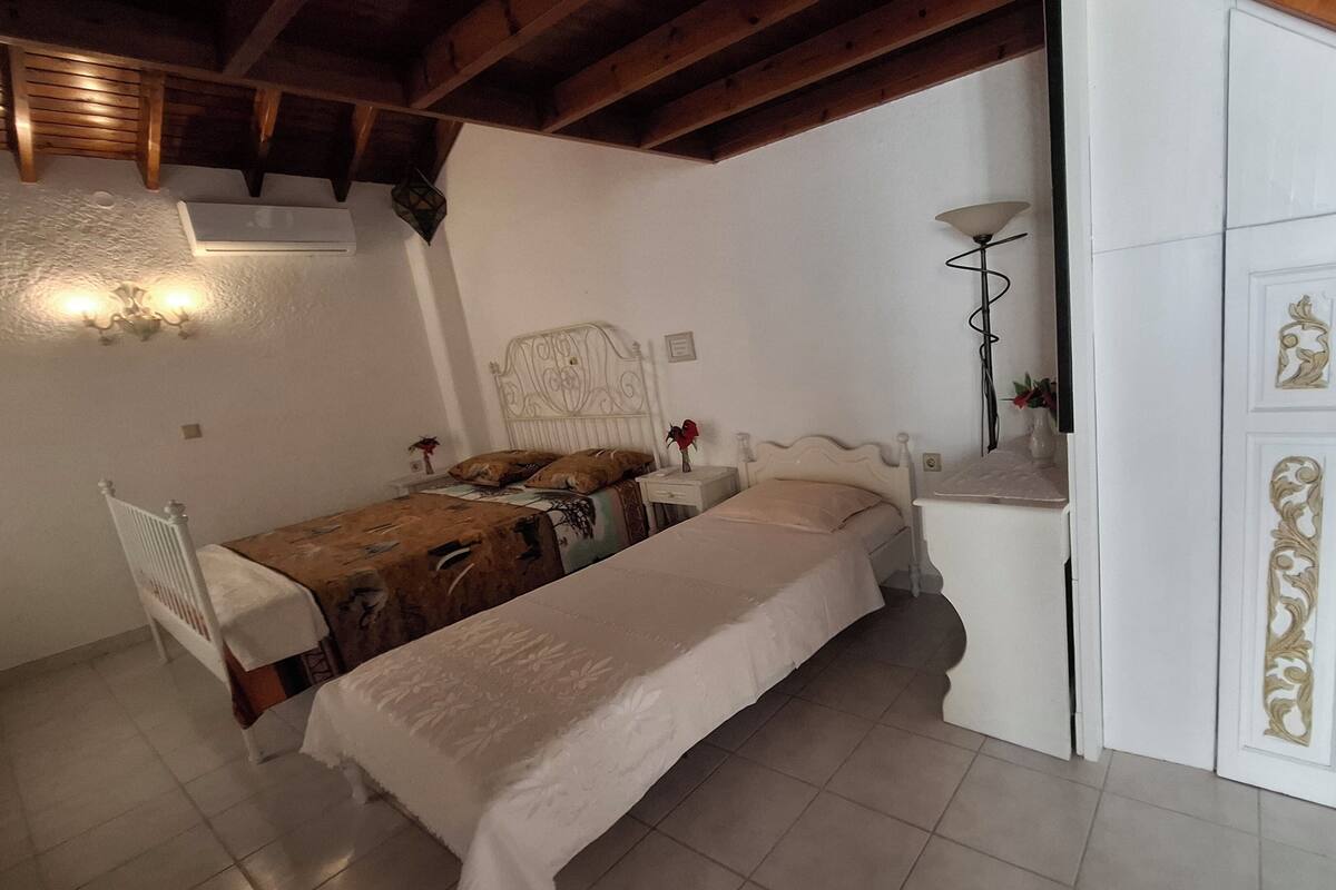 A bedroom with a bed, bedside tables, a nightstand, a lamp, and a wardrobe with decorative doors.