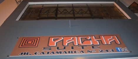 A hotel sign with the name "Pachita Suite" and address "Jr. Cajamarca No 243".