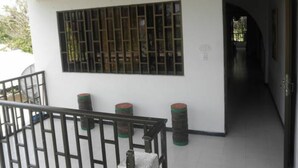 A hallway with a wooden ceiling, a barred window, and a staircase with a metal railing. - Ground Road Native Place (San Andrés)