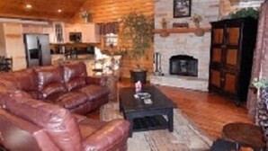 Una sala de estar acogedora con un sofá de cuero, chimenea y comedor.