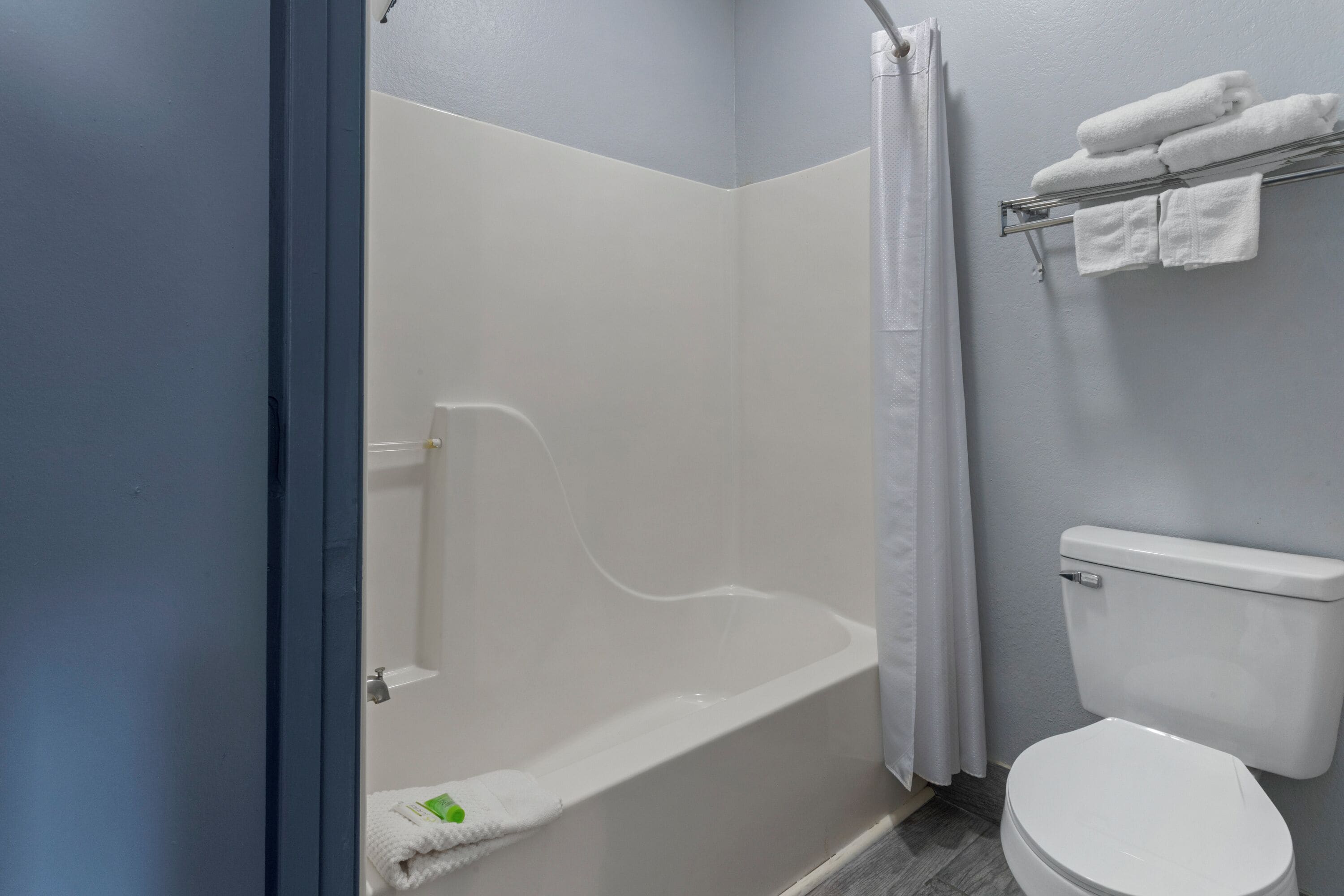 Un baño con bañera, inodoro y perchero para toallas.