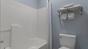 A bathroom with a bathtub, toilet, and towel rack.