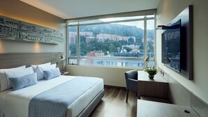 Een moderne hotelkamer met een groot bed, een bureau en een televisie.