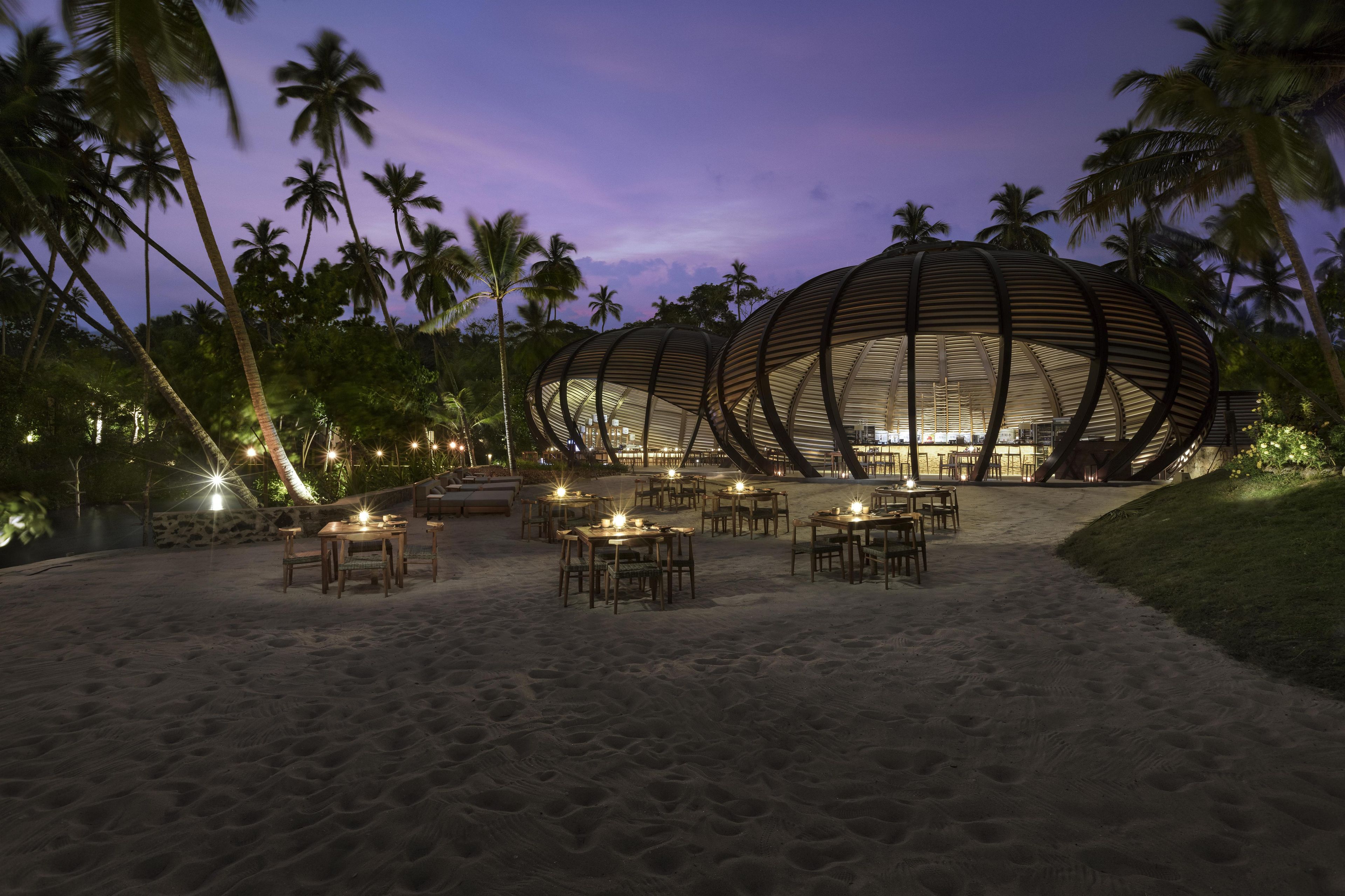 A beachside restaurant with outdoor seating and a distinctive dome-shaped building.