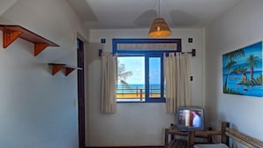 A room with a view of the ocean, a television, a bed, and a painting on the wall. - Apart Hotel Casa Grande (Natal)