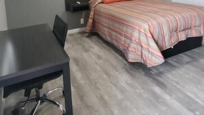 A bedroom with a bed, a desk, and a chair. - Villa Rosa Motel (Painesville)
