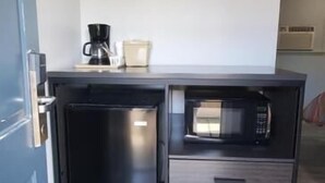 A compact kitchenette with a microwave, coffee maker, and a small refrigerator. - Villa Rosa Motel (Painesville)
