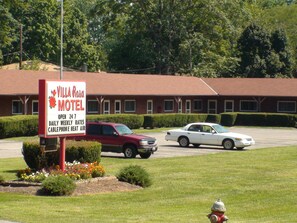 A Villa Rosa Motel sign with a red and white color scheme, indicating it is open 24 hours daily, weekly rates, and has a cablephone and heat air. - Villa Rosa Motel (Painesville)
