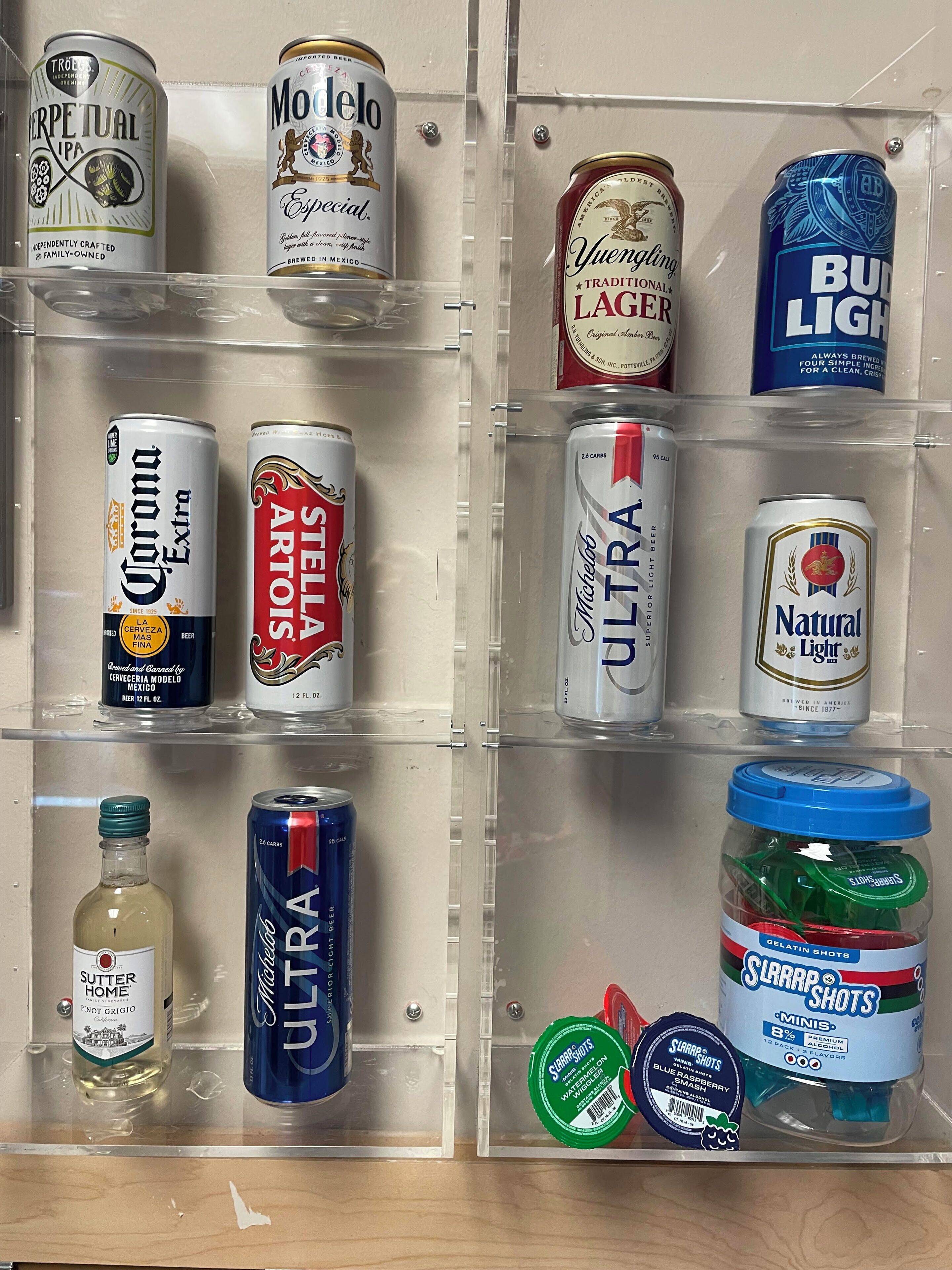 A beverage storage unit with various cans and bottles.