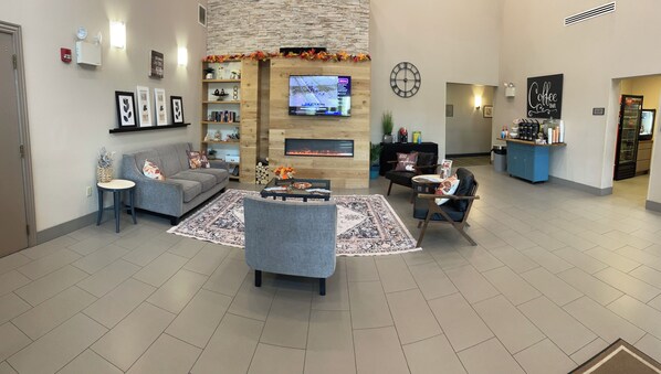 A modern living room with a fireplace, television, and seating area. - Country Inn & Suites by Radisson, Harrisburg West Mechanicsburg (Mechanicsburg)