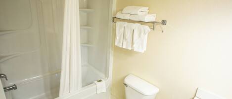 A bathroom with a bathtub, toilet, and towel rack.