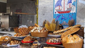 A variety of breads and pastries displayed in baskets and trays, with a decorative wall featuring a ship and sea creatures in the background. - Catamaran Quality Times - All Inclusive (Kemer)