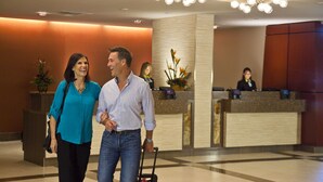 Eine Hotelhalle mit Empfangsschalter, einer großen Chandelier und einer Rezeption.