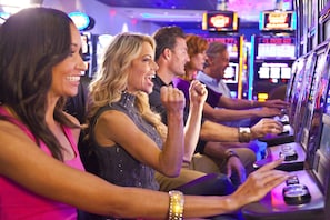 Un groupe de personnes jouant aux machines à sous dans un casino.