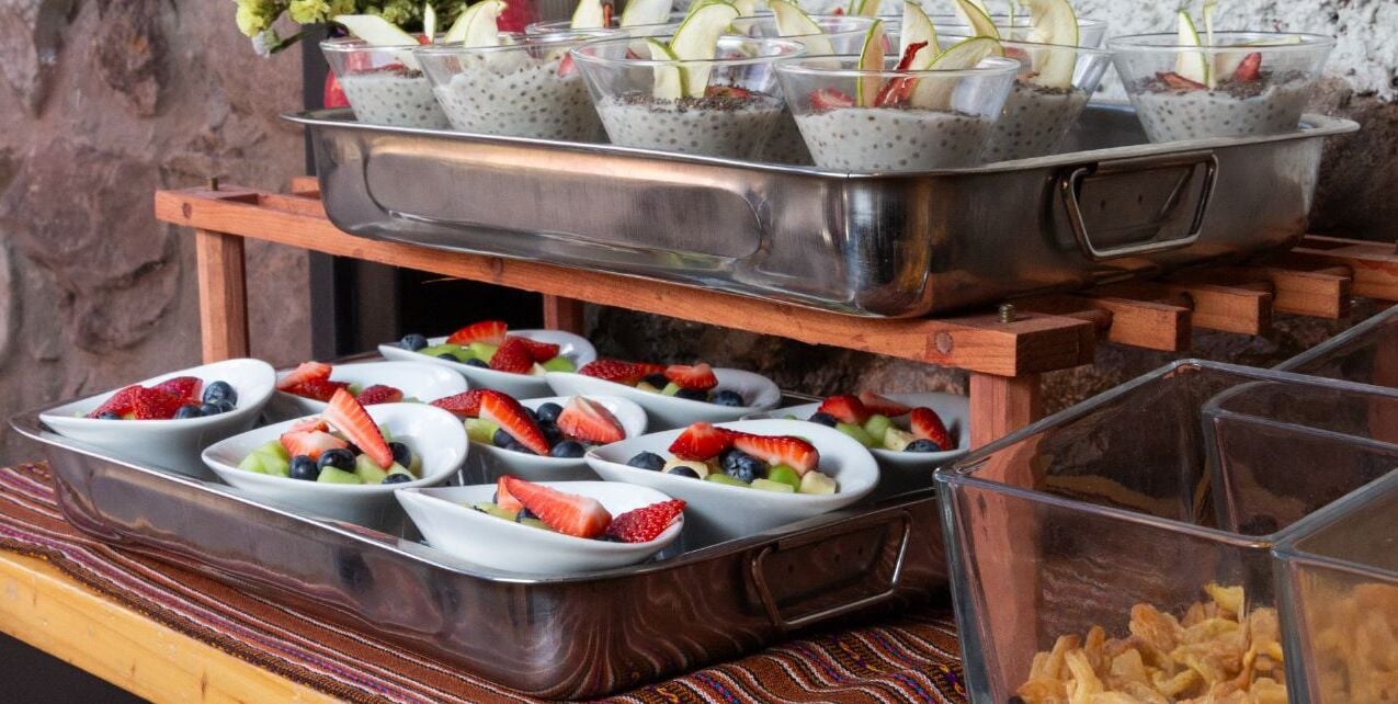 A buffet setup with various fruit bowls and chia seed bowls.