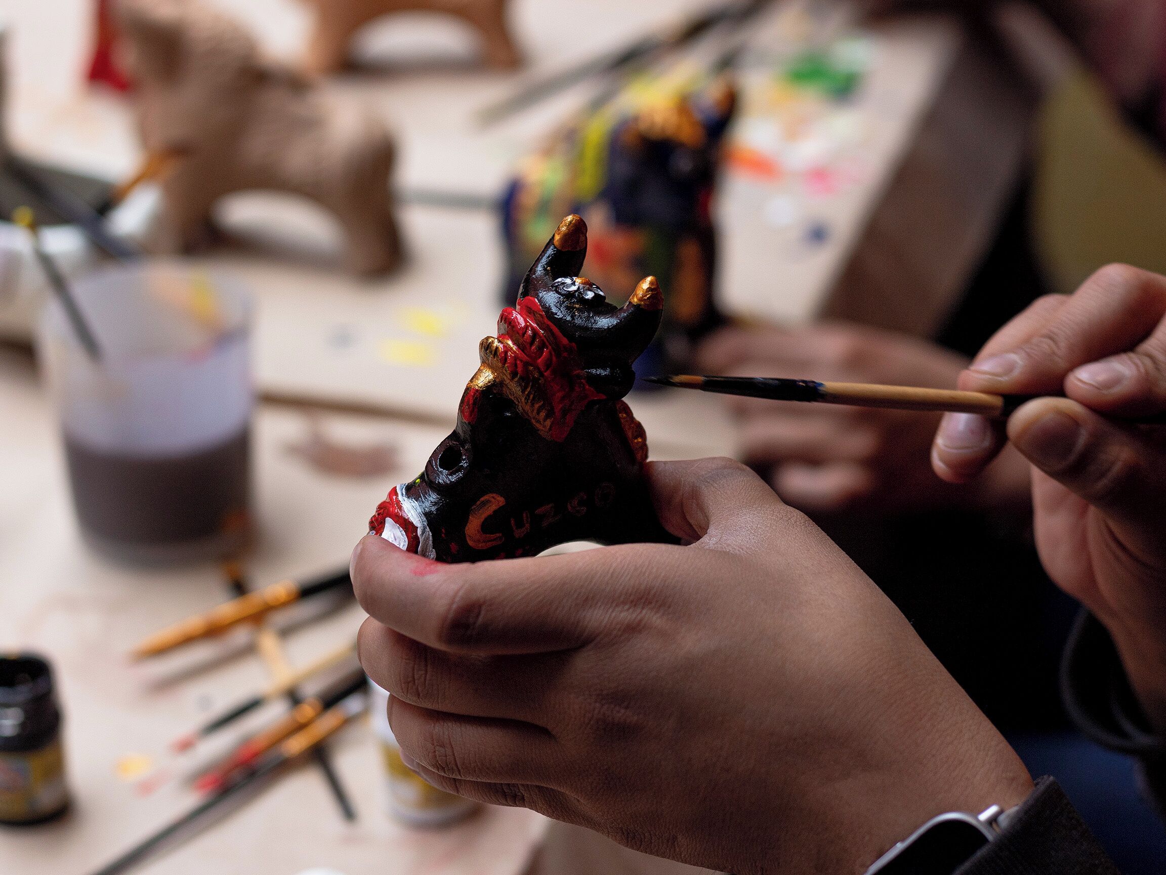 A person painting a sculpture with a brush.